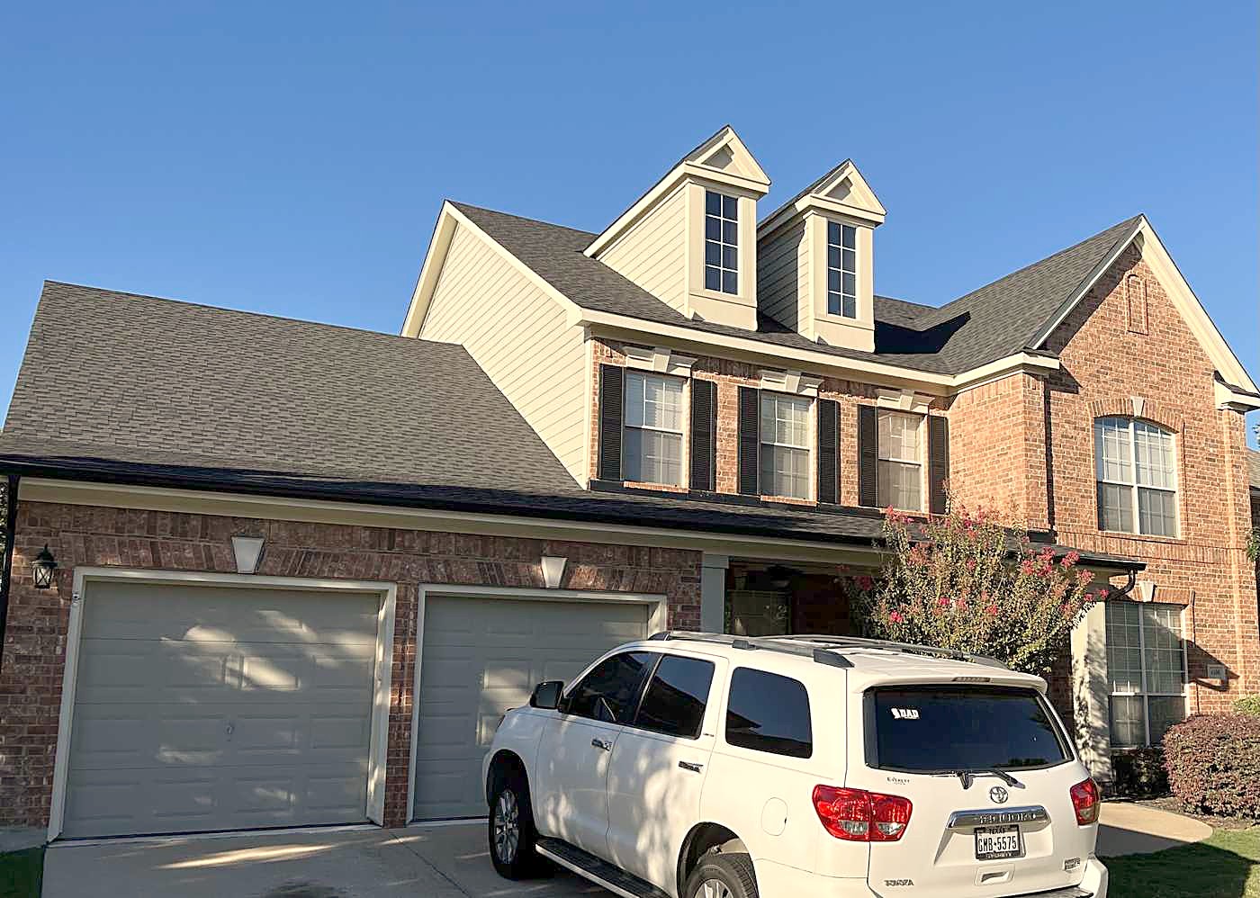 A two-story brick home with its new roof on